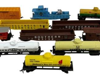 1608 - 11pc Lot HO Scale Train Cars (Description): A collection of 11 HO scale train cars  featuring a variety of freight and tank cars.  The lot includes rolling stock from various  railroad lines including Southern, Santa Fe,  Pennsylvania, Illinois Terminal, and Union Pacific. Tank cars feature company names such  as Magnolia Petroleum Co., Penn Salt, and  Hudson's Bay Oil and Gas (Procor). The  assortment includes boxcars, gondolas, tank  cars, a caboose, and a work car with crane,