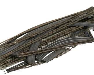 1667 - Lot Assorted HO Scale Train Tracks (Description): A lot of assorted HO scale train tracks  including various straight sections, curved  sections, and track switches. The collection  features multiple track configurations  suitable for model railroad layouts, with both standard track pieces and specialty  turnout switches for creating complex rail  networks.