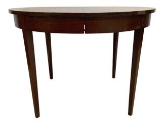 7689 - Round Mahogany Dining Table 30"x42" (Description): Crafted in mahogany with a rich, dark finish.  The table is supported by four elegantly  tapered legs in the Federal style. The apron  is unadorned, allowing the warm wood grain to  be the focal point. Shows some age-appropriate wear to the finish. Measures  30 inches in height by 42 inches in width.