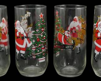1017 - 4 Vtg Christmas Glasses w/ Santa & Reindeer (Description): Set of four vintage Christmas drinking  glasses featuring colorful holiday scenes.  Each glass is decorated with Santa Claus, his  reindeer and sleigh, and a decorated  Christmas tree with a red star topper. The festive designs are rendered in traditional  red, green, gold, and white colors against  clear glass.