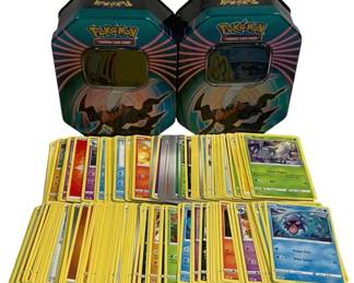 1569 - Lot of 205 Pokemon Cards w/ 1 Box & 10 Coins (Description): Collection of 205 Pokemon Trading Card Game  cards accompanied by two collectible storage  tins featuring Charizard artwork and 10 game  coins. The cards span various types including  fire, water, grass, and psychic Pokemon. The tins are hexagonal-shaped with vibrant  graphics from the Pokemon Trading Card Game  series.