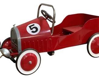 1554 - Vtg Metal Pedal Car Morgan Style Red #5 (Description): Vintage metal pedal car in the Morgan style,  featuring a vibrant red body with the number  5 displayed on the side. This charming toy  car includes classic details such as a chrome  roll bar, steering wheel, silver-painted headlamps and bullet-shaped front ornaments,  and a silver grille. The wheels feature red  centers with white rubber tires. Measures 34  x 16 x 20