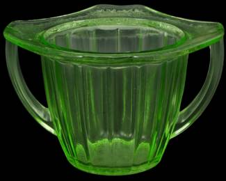 886 - Vtg Depression Uranium Glass Sugar Bowl (Description): Vintage Depression era uranium glass sugar  bowl featuring a distinctive green color with  a ribbed panel design. The bowl has two  applied handles and a decorative scalloped  rim with embossed detailing. Measures 3 inches tall by 5 inches wide by 5 inches  deep.