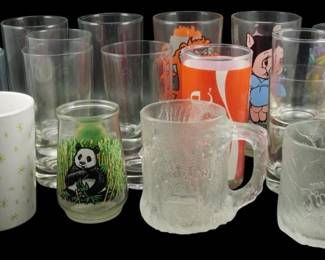 1019 - Assorted Character & Novelty Glasses (Description): Assorted collection of drinking glasses  featuring various character and novelty  designs. The lot includes Flintstones frosted  glass mugs, a panda-decorated juice glass,  character tumblers including what appears to be Hanna-Barbera designs, a Happy Holidays  snowman mug, and various clear drinking  glasses in different sizes. The collection  spans promotional fast food glasses,  decorative tumblers, and ceramic mugs.