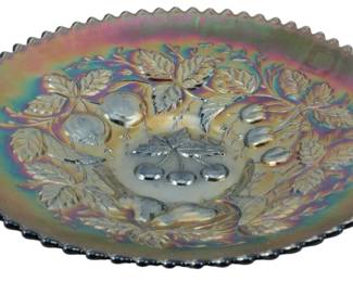 712 - Vtg Northwood Amethyst Three Fruits Carnival (Description): Vintage Northwood amethyst carnival glass  plate in the Three Fruits pattern. This  decorative piece features a raised design of  cherries, pears, and apples surrounded by  detailed foliage and leaves. The plate displays the characteristic iridescent finish  of carnival glass with rainbow hues of  purple, green, blue, and gold. The rim  features a distinctive crimped or pie crust  edge typical of Northwood carnival glass