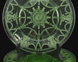 895 - Vtg 1930s Cameo Uranium Glass Plates Set of 5 (Description): Vintage 1930s Cameo pattern uranium glass  plates, set of five. These Depression-era  plates feature an elegant etched design with  classical motifs including draped swags,  medallions, and ornate scrollwork radiating from a central rosette. The distinctive green  uranium glass glows under UV light. Each  plate measures 9 inches in diameter.