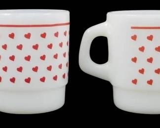1145 - Set of 4 Termocrisa Heart Mugs 3.5" (Description): Set of four Termocrisa stackable mugs  featuring a charming red heart pattern on  white milk glass. Each mug is decorated with  scattered red hearts across the body and  accented by a red stripe near the rim. The mugs feature the classic D-handle  designtypical of Fire-King style stackable  mugs. Each mug measures 3.5 inches tall.
