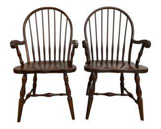 7671 - Pr Windsor Style Spindle Back Armchairs (Description): Pair of Windsor style spindle back armchairs  in a rich dark brown finish. These classic  chairs feature curved bow backs with tall  spindles, shaped wooden seats, turned legs,  and decorative stretchers. Each chair has scrolled arms supported by turned spindles.  Measures 38"x18"x22".