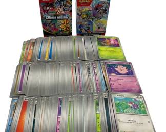 1567 - Lot of 203 Pokemon Cards w/ 1 Tin & 1 Box (Description): Lot of 203 Pokemon trading cards accompanied  by one tin and one box. The collection  includes two booster bundle boxes: Scarlet &  Violet Chaos Rising and Journey Together.  Cards feature various Pokemon characters including Clefairy, Rattata, and others  across multiple card types and rarities. The  cards display a range of colored borders  indicating different energy types and sets.