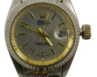 837 - Reproduction Rolex Two-Tone Ladies Watch (Description): A reproduction Rolex ladies watch in a  two-tone design featuring both stainless  steel and gold-tone metal. The watch displays  a Datejust style with a textured silver  dial, gold-tone bezel, date window at 3 o'clock, and matching two-tone Jubilee-style  bracelet. Features a fluted bezel design and  crown logo on the dial face. Used as is electric/electronic/mechanical  item. No guarantee all components, untested.