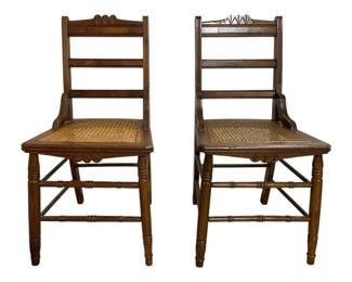 7663 - Pair Walnut Vintage Cane Seat Side Chairs (Description): Walnut side chairs featuring woven cane  seats. Each chair has a carved decorative  crest rail with Gothic-inspired cutout  details, ladder-style horizontal back slats,  and gracefully curved arms on the stiles. The chairs rest on turned front legs with  stretcher supports. Measures 33 inches high  by 17 inches wide by 17 inches deep.
