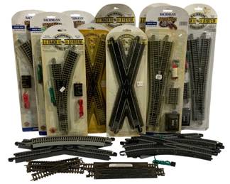 1074 - Bachmann E-Z Track HO Scale Train Track Lot (Description): Assorted lot of HO scale train tracks  featuring multiple Bachmann E-Z Track System  pieces. The lot includes both new-in-package  and loose track sections. Packaged pieces  include remote switch tracks, crossing tracks, and straight sections with nickel  silver rails. Loose pieces include various  curved tracks, straight sections, and switch  tracks. A substantial collection suitable for  expanding or building an HO scale model