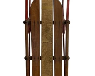 7702 - Vintage Wooden Snow Sled w/ Red Metal Frame (Description): Vintage wooden snow sled featuring a classic  design with wooden slat seat and red painted  metal frame and runners. The sled has curved  wooden steering handles at the top. Measures  46"x29"x7".