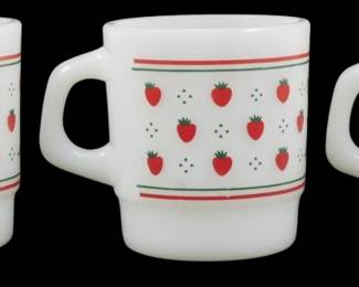 1138 - Set of 3 Termocrisa Strawberry Mugs 3.5" (Description): Set of three Termocrisa strawberry mugs in  white milk glass. Each mug features a  charming pattern of red strawberries with  green stems arranged in rows, accented by  small green dots and horizontal red and green stripes near the rim and base. The mugs have  a classic stacking design with D-shaped  handles. Each measures 3.5 inches tall.