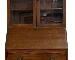 7715 - Chippendale Bookcase Top Secretary (Description): Traditional mahogany bookcase secretary  featuring a swan neck pediment with central  finial. The upper section has two glass-paned  doors opening to adjustable shelving. The  slant-front desk opens to reveal a fitted interior. Below, three serpentine drawers  with brass bail pulls provide ample storage.  The piece rests on carved ball and claw feet.  Measures 78 inches high by 30 inches wide by  16 inches deep.