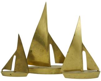 788 - 3 Mid Century Solid Brass Sailboat Sculptures (Description): Set of three Mid Century solid brass sailboat  sculptures in graduated sizes. Each features  a stylized modernist design with sleek  triangular sails mounted on elongated hull  bases. The brass displays a warm golden patina consistent with age. The largest  measures 10 inches tall.