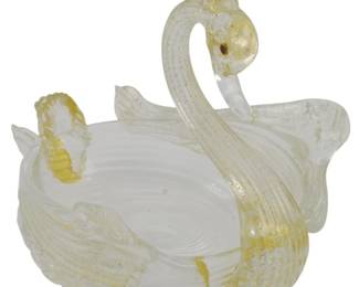 764 - Vtg Salviati Art Glass Swan 4.5"x5"x4" (Description): Vintage Salviati art glass swan, handcrafted  in the Murano tradition. This elegant piece  features clear glass with white latticino  swirls throughout the body and gold  aventurine inclusions adorning the neck, head, tail, and wing tips. The swan form  creates a graceful open bowl or dish, with  delicate feathered wings and a curved neck  topped with a decorative crest. Measures 4  1/2" x 5" x 4".