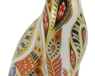 800 - Royal Crown Derby Siamese Cat Paperweight (Description): Royal Crown Derby Siamese Cat paperweight  featuring the maker's signature Imari-style  decoration in rich cobalt blue, orange, and  gold tones with intricate paisley and floral  patterns. The seated cat has a white porcelain body with hand-painted detailing  and gilt accents. Fitted with a silver  stopper on the base. Measures 5.5 inches  tall.