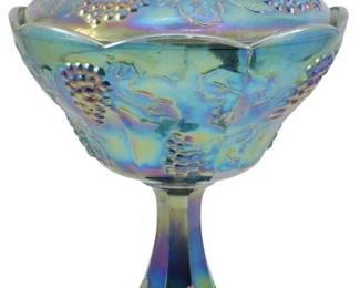 627 - Indiana Harvest Grape Carnival Compote (Description): Carnival glass compote with lid, measuring  10.5 inches in height. Features iridescent  finish with raised grape and vine pattern  throughout the bowl, lid, and pedestal base.  Lid topped with decorative finial.