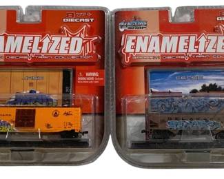 1032 - 2pc. Lot Enameled Train Cars (Description): Two piece lot of enameled train cars. These  die cast collectible train cars feature  graffiti-style designs from the Enamelized  Graffiti Die Cast Train Collection.