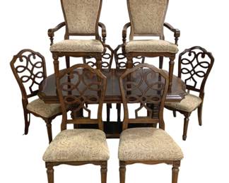7733 - Dark Wood Dining Table & Chair Set (Description): Traditional dining table and chair set in  dark wood finish. The table features elegant  turned legs with decorative carved details,  connected by a curved stretcher base with  molded edges. The rectangular top has clipped corners and appears to be expandable.  Classic formal styling suitable for a dining  room. Measurements: 44"x25"x29 (31"x48"x70)  94".