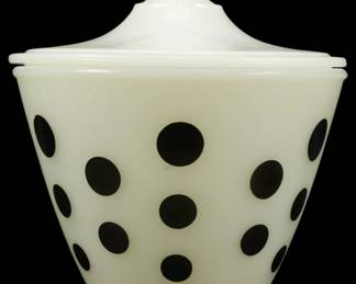 1026 - Fire King Black Polka Dot Grease Jar w/ Lid (Description): Fire King grease jar with lid featuring a  charming black polka dot pattern on white  milk glass. This vintage kitchen collectible  has a tapered bowl shape with a fitted lid  topped by a round finial knob. A classic mid-century piece in the popular polka dot  design.
