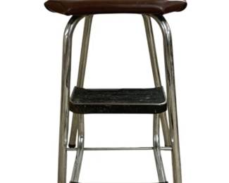 7632 - Vintage Chrome Step Stool Chair 36"x26"x14" (Description): Vintage chrome step stool chair featuring a  brown vinyl padded seat and wire spindle  back. The stool includes two pull-out black  rubber-treaded steps for added functionality.  This mid-century style kitchen helper combines seating with step stool convenience.  Measures 36 inches high by 26 inches deep by  14 inches wide.