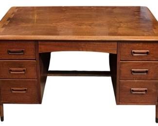 7610 - Lane Acclaim Mid-Century Modern Walnut Desk (Description): Lane mid-century modern desk in inlaid walnut  finish featuring a kneehole design with  three drawers on each side. The desk  showcases characteristic MCM styling with  recessed drawer pulls and tapered legs with dark ferrules. Comes with fitted glass top.  Measures 30 inches high by 50 inches wide by  23 inches deep.