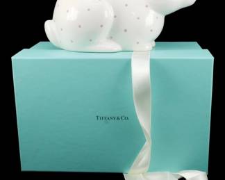 902 - Tiffany & Co. Porcelain Bunny Piggy Bank (Description): Vintage Tiffany & Co. porcelain bunny piggy  bank with original box and ribbon wrap. The  charming white ceramic rabbit features a pink  polka dot pattern throughout the body with  delicate pink accent details on the ears and eyes. Comes complete in the signature Tiffany  blue box with white satin ribbon. Measures 5  inches by 8 inches by 4 inches.