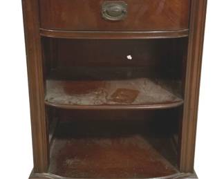 7662 - Mahogany Night Stand w/ Drawer and Shelves (Description): Traditional mahogany night stand featuring  one drawer with an oval brass pull and two  open shelves below. The piece has a curved  front design with fluted column details on  the sides and rests on bracket feet. The rich dark finish shows classic styling consistent  with mid-20th century furniture design.