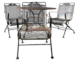 7699 - Metal Mesh Outdoor Table & Chair Set (Description): Outdoor table and chair set featuring an  expanded metal mesh design. The set includes  a round table and four spring-base armchairs  with decorative scroll crest rails. The  chairs feature mesh seats and backs with curved armrests. Finished in a dark  bronze/black patina. Table measures 30 inches  by 42 inches; chairs measure 35 inches by 21  inches by 23 inches.