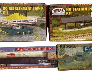 1671 - 4pc Lot Atlas HO Scale Model Railroad Kits (Description): A lot of four Atlas HO scale model railroad  kits. The collection includes an HO  Refreshment Stand Kit, an HO Station Platform  Kit, a Plate Girder Bridge Kit, and a Barn  structure kit. All kits are in their original packaging and are designed for HO scale  model railroad layouts.