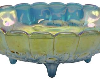 738 - Indiana Electric Blue Harvest Carnival Bowl (Description): Vintage Indiana Electric Blue Harvest  Carnival Glass Bowl featuring the classic  fruit pattern with grapes and leaves in  relief around the exterior. This footed oval  centerpiece bowl displays beautiful iridescent blue and amber tones with a  scalloped rim edge. The bowl rests on four  small feet. Measures 4.5 inches tall by 12  inches long by 8 inches wide.