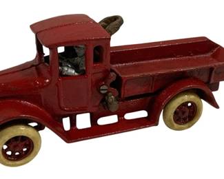 1519 - Vtg Cast Iron Dump Truck 10"x3.5"x4.5" (Description): Vintage cast iron dump truck toy in red paint  with white rubber tires and a nickel-plated  driver figure. The truck features an enclosed  cab with open windows and a tilting dump  bed. Measures 10" x 3.5" x 4.5".