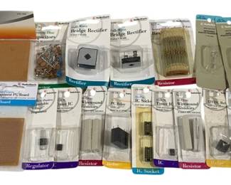 1641 - Lot Vintage Computer Parts (Description): Lot of vintage electronic components and  computer parts, primarily Radio Shack brand  items in original packaging. Collection  includes prepunched perfboards, PC boards,  full-wave bridge rectifiers, capacitors, IC sockets, IC timer chips, PC relays,  resistors, wire wound resistors, voltage  regulators, and a Peco Lectrics turnout  motor. Most components remain in their  original retail blister packs with product