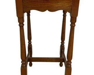 7652 - Vintage Turned Leg End Table w/ Drawer (Description): Vintage wooden end table featuring a single  drawer with round wooden knob pull. The table  showcases turned legs with decorative  turnings and a scalloped apron detail.  Connected by stretcher base for stability. Finished in a warm medium brown tone.  Measures 30 inches tall by 17 inches wide by  17 inches deep.