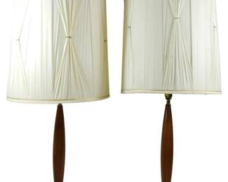 944 - Mid Century Pr Walnut & Brass Table Lamps 36" (Description): Pair of Mid Century Modern walnut and brass  table lamps measuring 36 inches tall. Each  lamp features an elegant tapered walnut  column with a gently curved hourglass  silhouette, mounted on a round walnut base with brass accent ring. The lamps are fitted  with gathered pleated fabric drum shades in  cream with gold trim edging. Both lamps are  in working condition with original wiring. Used as is electric/electronic/mechanical