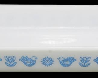 1213 - Glassbake Bird & Flower Baking Dish (Description): Glassbake rectangular baking dish featuring a  charming blue bird and flower folk art  pattern on white milk glass. The decorative  motif includes stylized birds alternating  with tulips and sunflower designs along the front exterior. Measures 2 incheshigh by 12  inches long by 7 inches wide.