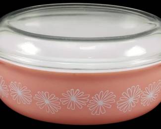 1117 - Pyrex Pink Daisy Casserole w/ Lid 4"x10"x6.5" (Description): Vintage Pyrex Pink Daisy casserole dish with  clear glass lid. The oval dish features a  charming pink body decorated with a white  daisy starburst pattern around the exterior.  The casserole has integrated handles on each end and comes with its original fitted clear  glass lid. Measures 4 inches tall by 10  inches long by 6.5 inches wide.