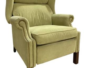 7711 - Hancock & Moore Green Upholstered Recliner (Description): Upholstered wingback recliner chair in sage  green fabric. Features rolled arms with brass  nail head trim detailing along the arm  fronts and sides. The chair has a high back  with attached pillow headrest and cushioned seat. Supported by dark wood square tapered  legs. Measures 46 inches high by 38 inches  wide by 33 inches deep.