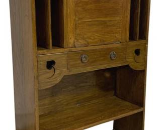 7763 - English Antique Oak Drop Front Secretary Desk (Description): Antique oak drop front secretary desk  featuring a shaped gallery top with curved  corners. The upper section includes divided  compartments on each side with arched  openings, flanking a central cubby space. The drop front writing surface is fitted with  brass hardware and reveals a storage area  when open. Two small pull-out writing slides  extend from either side. The lower section  offers open shelf storage. The piece rests on