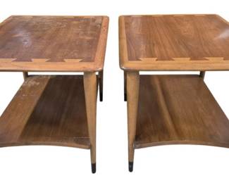 7605 - Pair Lane Acclaim MCM Two-Tier End Tables (Description): Featuring warm walnut inlaid wood  construction with two-tier design. Each table  has a rectangular top with rounded edges,  supported by tapered legs with dark  contrasting foot caps. A lower shelf provides additional display or storage space. The  clean lines and sculptural legs are  characteristic of mid-century design.  Measurements: 20" x 28" x 22". One is Clean the other Needs Staining &