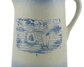 742 - Vintage Stoneware Blue & White Pitcher 9" (Description): Vintage stoneware pitcher featuring classic  blue and white coloring. The pitcher displays  a charming transfer-printed scene depicting  figures in a pastoral or domestic setting,  framed by a decorative scalloped border. The body shows characteristic salt-glazed finish  with blue banding at the rim and base, and  displays fine crazing consistent with age.  Measures 9 inches tall.