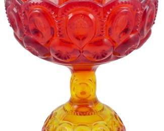 994 - Vtg L.E. Smith Amberina Moon & Star Compote (Description): Vintage L.E. Smith Amberina Moon & Star  pattern compote featuring the classic pressed  glass design with a beautiful red to amber  gradient coloring. The bowl displays the  distinctive Moon & Star motif with a scalloped edge, while the pedestal base  continues the pattern. Measures 6 1/2" x 6".