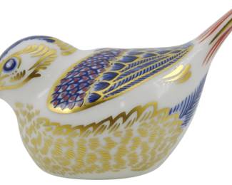 798 - Royal Crown Derby Goldcrest Paperweight (Description): Royal Crown Derby Goldcrest paperweight  featuring the gold stopper, indicating first  quality. The piece is decorated in the  traditional Imari color palette of cobalt  blue, rust red, and 22-carat gold accents on a white bone china body. The charming  songbird displays intricate hand-painted  feather detailing on the wings and breast.  Measures 2.5 inches.
