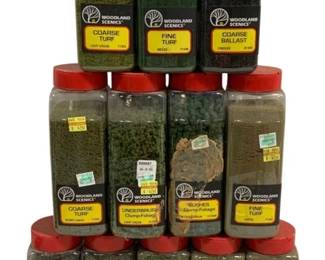 1693 - 12 pc Woodland Scenics Turf & Foliage Lot (Description): A lot of 12 Woodland Scenics bottles for  model railroad and diorama landscaping. The  collection includes a variety of scenic  materials such as Coarse Turf, Fine Turf,  Coarse Ballast, Underbrush, and Bushes Clump-Foliage. Colors range from light green  and dark green to earth tones and cinders.  Each bottle features the distinctive red cap  and Woodland Scenics labeling. An excellent  assortment for hobbyists looking to add