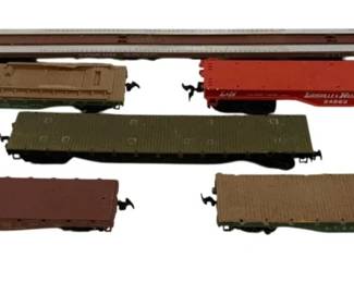 1575 - 6pc Lot HO Scale Flatbed Train Cars (Description): A collection of six HO scale flatbed train  cars featuring various railroad liveries. The  lot includes cars in assorted colors  including brown, olive green, red, and tan.  Notable pieces include a Louisville & Nashville car and a Union Pacific car. The  flatbed styles vary, with some featuring  raised side stakes and others presenting  smooth deck surfaces. All cars are equipped  with standard HO scale couplers.