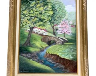 7722 - E. Fleckenstein Signed Landscape Oil Painting (Description): Framed hand-painted canvas artwork signed by  E. Fleckenstein in the lower left corner. The  landscape painting depicts a serene spring  garden scene featuring a stone arch bridge  over a gentle stream, lush green trees, and flowering shrubs in pink and white blooms.  Presented in an ornate gilt wood frame with  carved floral corner details and cream mat.  Measures 20" x 16".