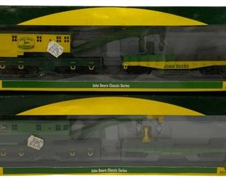 1628 - Athearn 2pc John Deere Train Cars HO (Description): Athearn two-piece set of John Deere Classic  Series train cars in HO scale. The set  includes two boxed cars featuring the iconic  John Deere yellow and green livery. One box  contains a yellow caboose and flatcar with equipment, while the other features green  passenger or freight cars. Both boxes display  the John Deere Classic Series branding and  Athearn Ready to Roll logo. Cars remain in  original packaging.