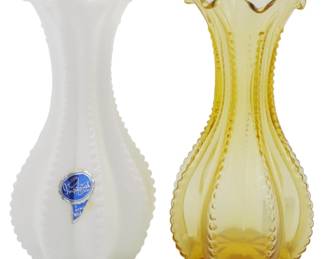 753 - 2 Imperial Glass Bud Vases 5" (Description): Two Imperial Glass bud vases measuring 5  inches tall. The pair features matching  beaded hobnail designs with elegant ruffled  scalloped rims. One vase is in milk glass  white retaining its original Imperial USA Genuine Milk Glass foil label, while the  other is in a warm amber or honey gold color.  Both display the characteristic paneled body  with vertical beaded ribs.